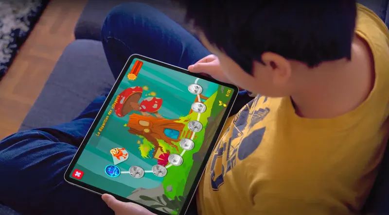 Un enfant tenant une tablette et jouant à Mila Learn