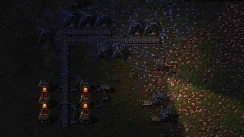 Vue de jeu officielle de Factorio accompagnant la pose d’une foreuse face à un four pour traiter le minerai de fer