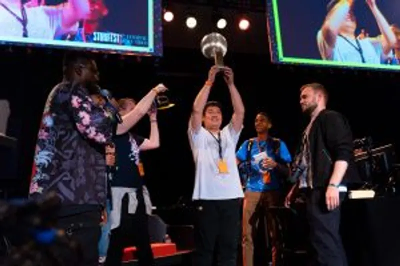 Les vainqueurs du podium du tournoi Guilty Gear : Strive, se tiennent sur la scène et célèbrent leur victoire.