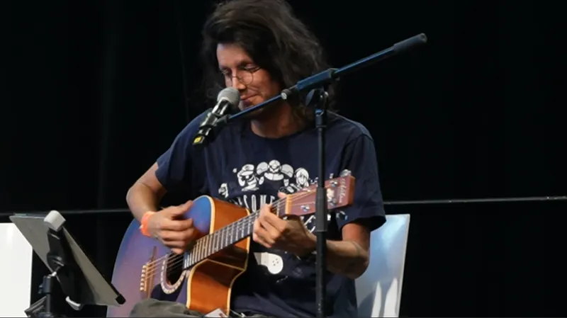 SpaceKaeru jouant de la guitare lors de son concert.