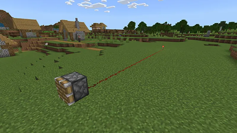 Ligne de poussière de redstone sur le sol dans Minecraft, avec composants espacés.